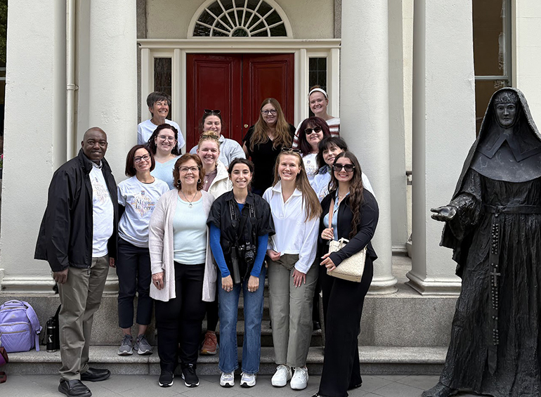 group photo of students with statue