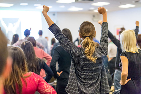 group of persons with arms raised