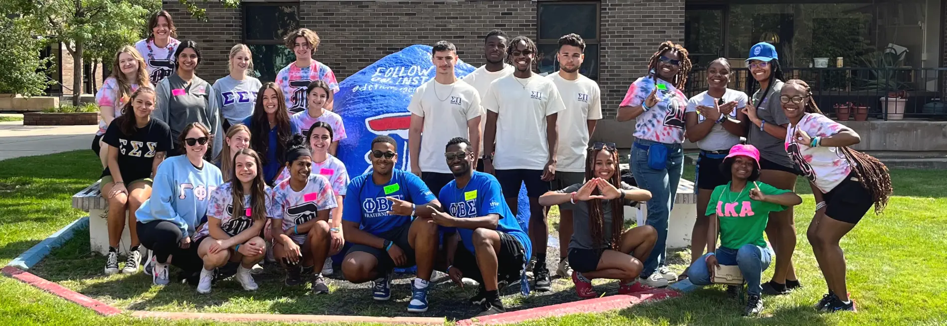 Greek groups gathered at the painted rock on McNichols Campus