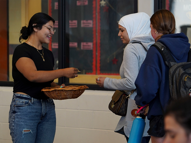 A student hands out an item to two other students during Celebrate Spirit.