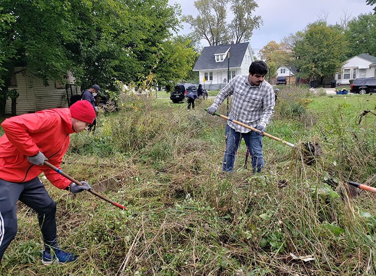 students raking and picking up garbage