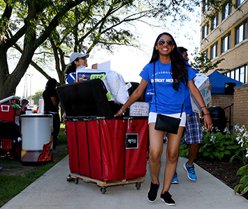 Female student using a cart on move-in day