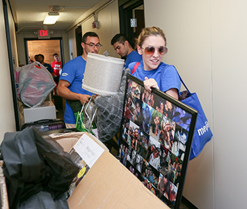 Dorm hall crowded with students and their stuff on move-in day