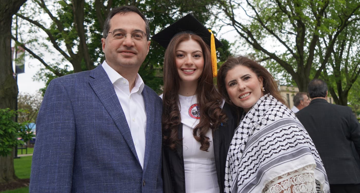 A Detroit Mercy graduate poses with her parents.