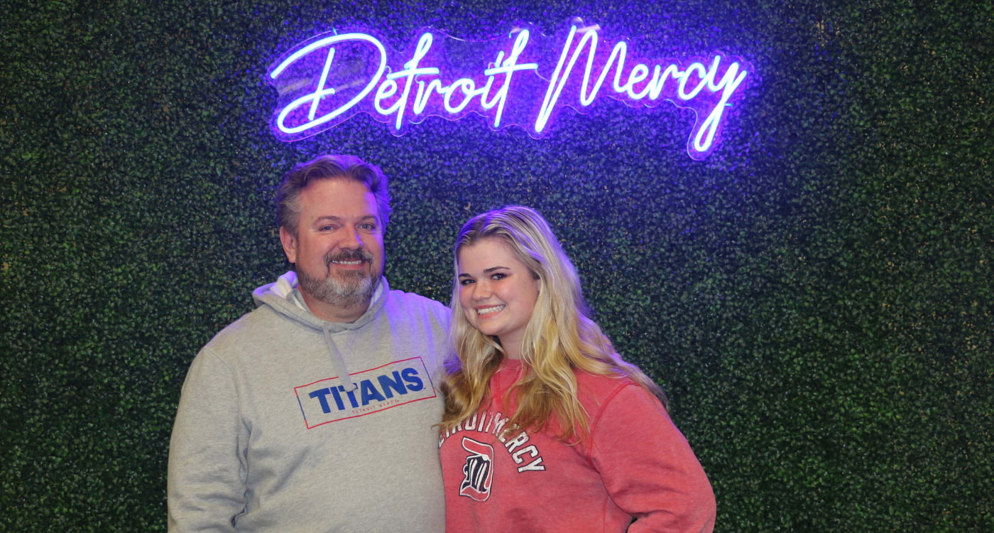 A student poses with her father.