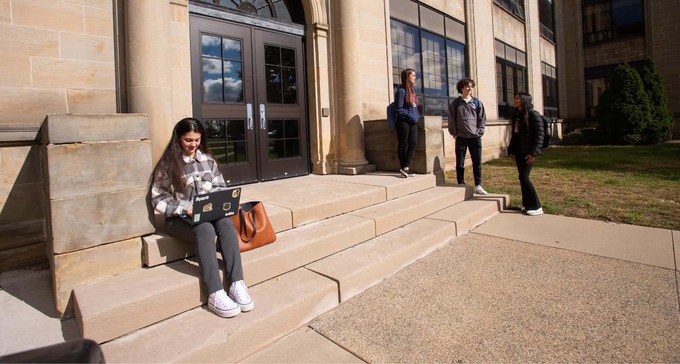 Students talk outside of an academic building.