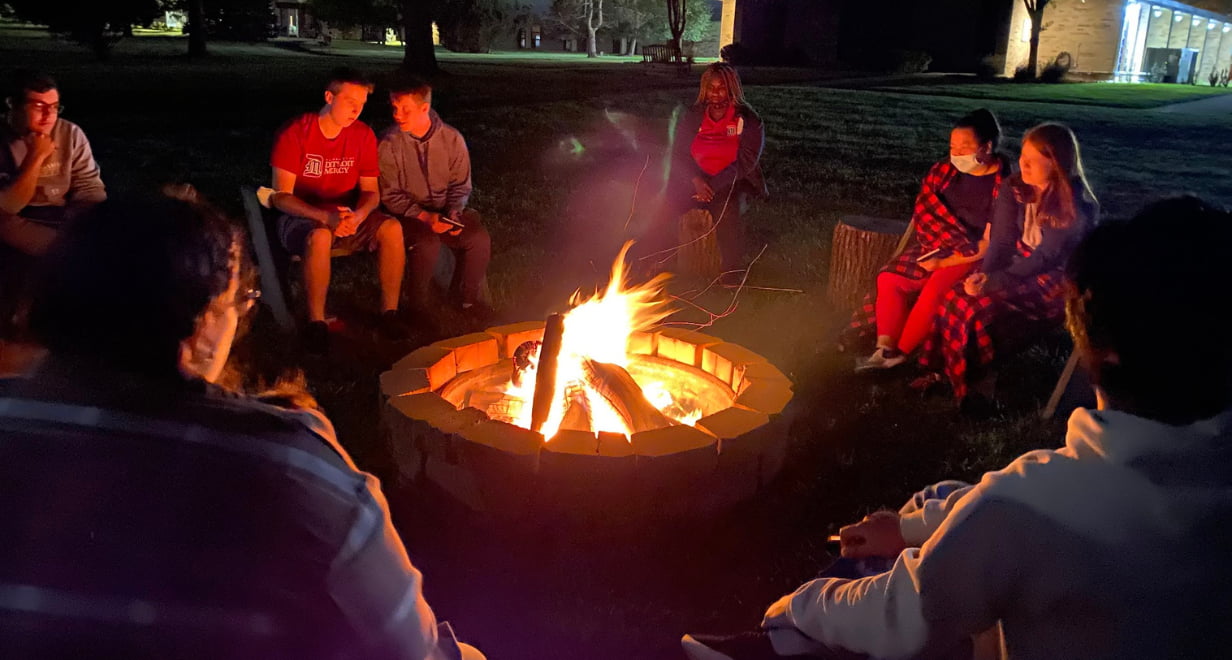 New Beginnings Retreat attendees sit around a bonfire.