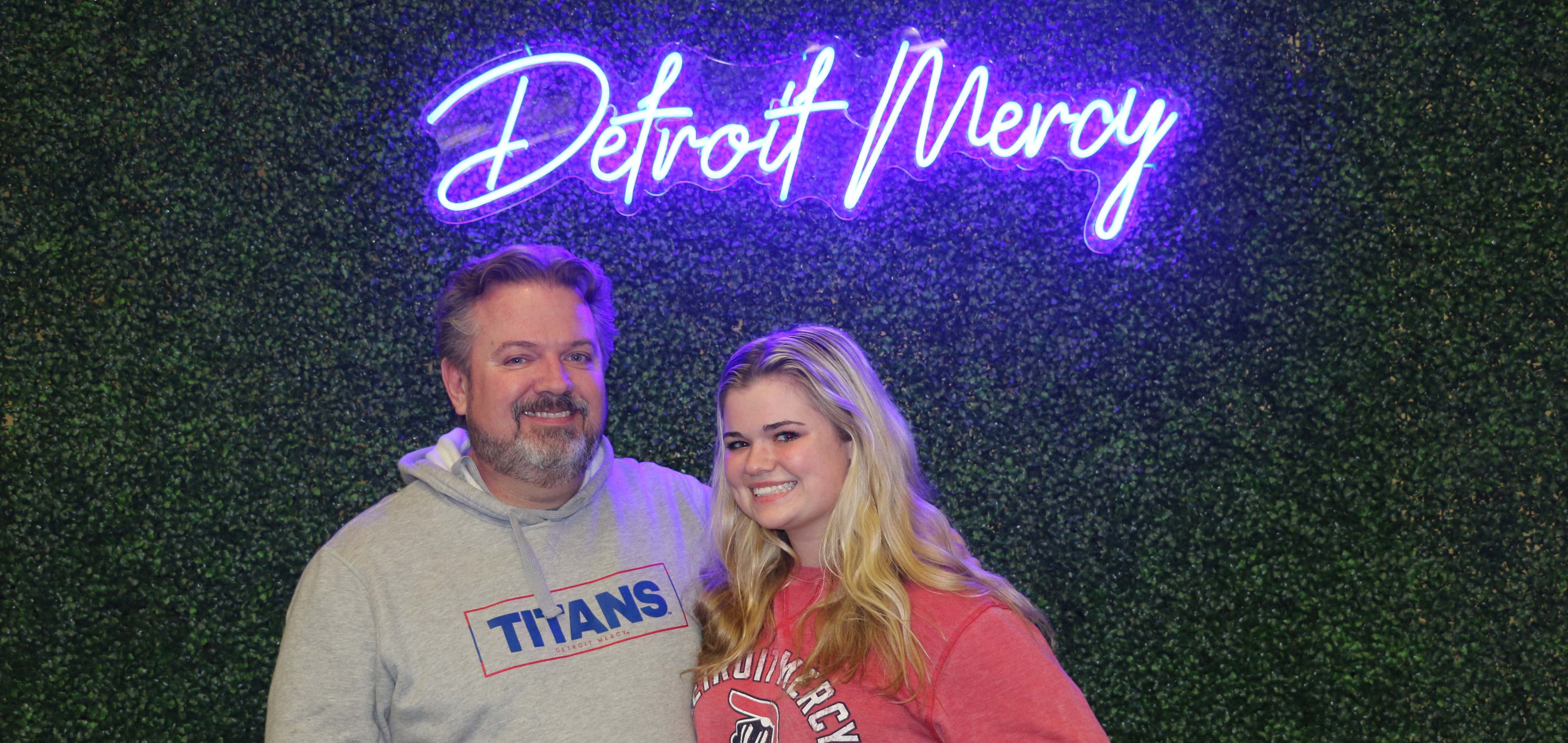A Detroit Mercy student poses with her parent.
