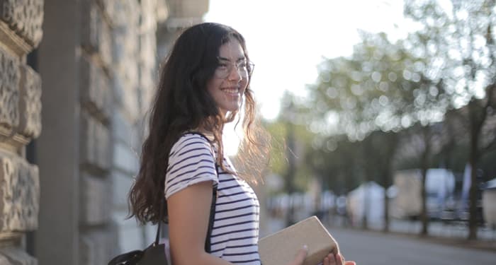 A female student stands outside.