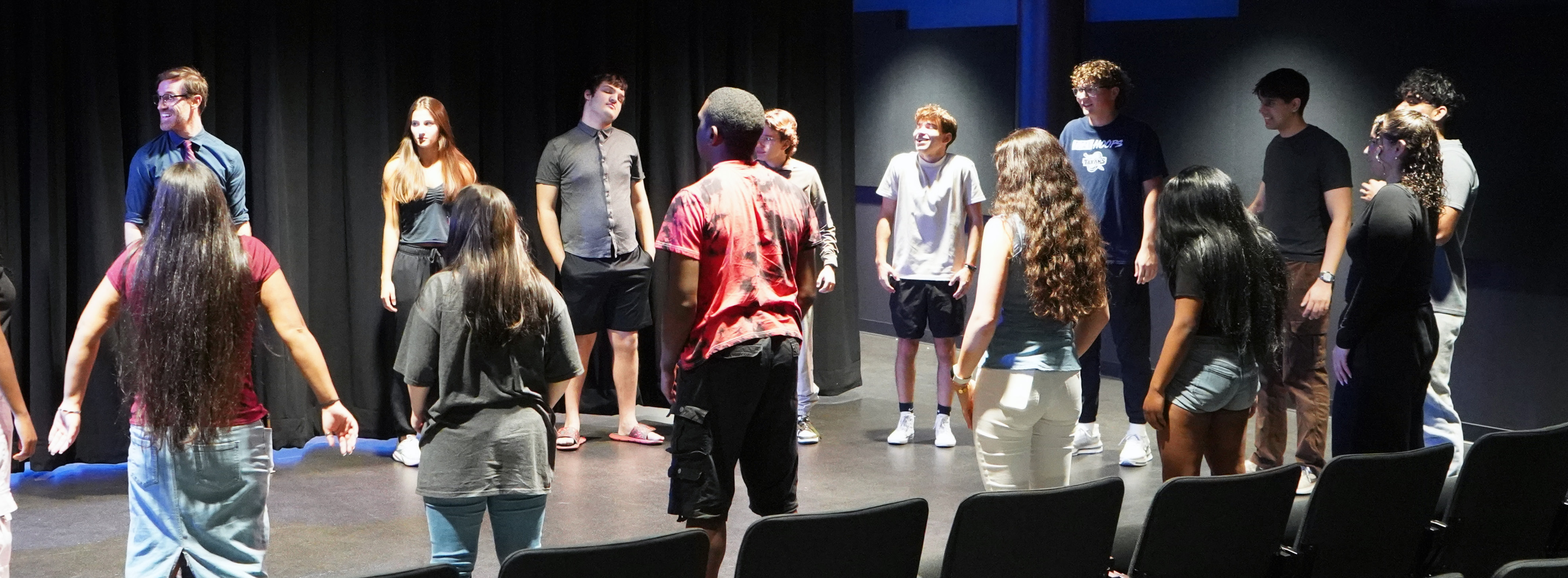 A circle of students learning in a theatre
