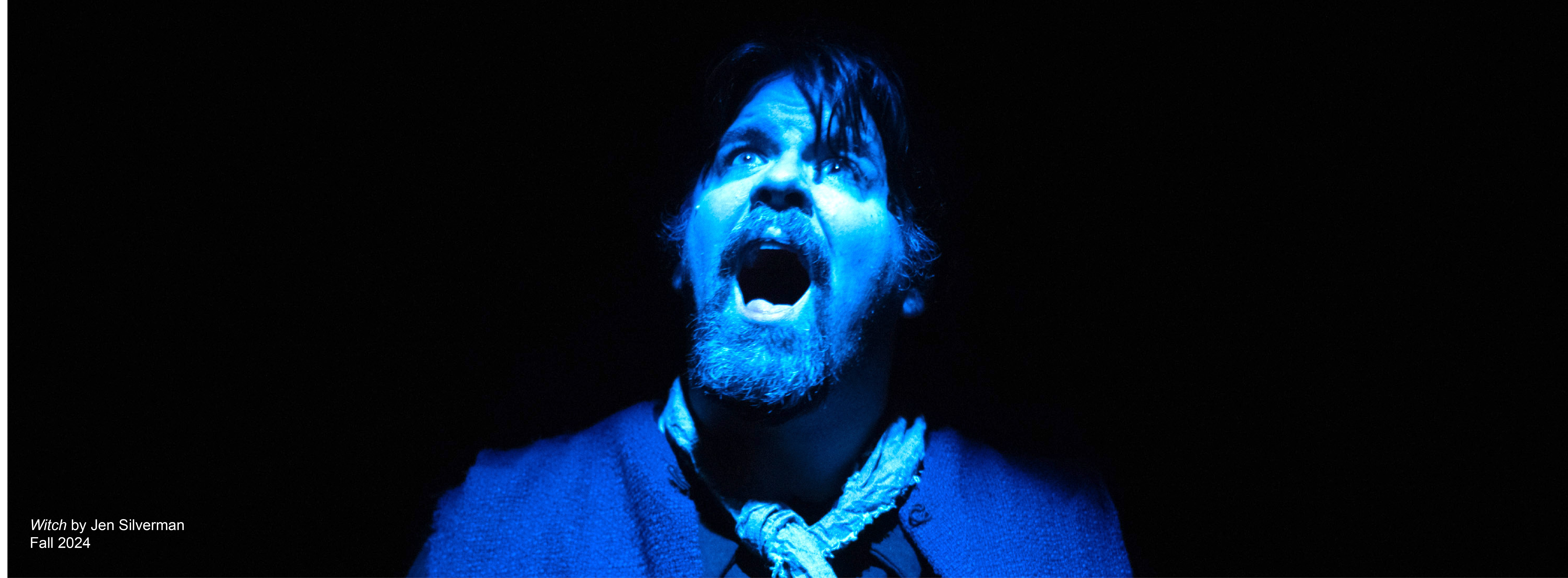 An actor screams at the sky bathed in blue light