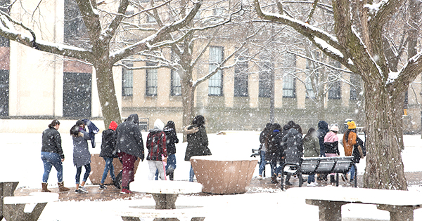 around twenty students walking to class in a winter snow